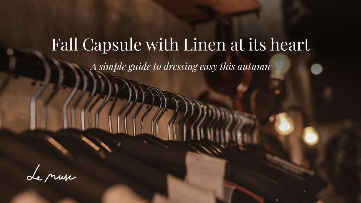 Mørkt tøjstativ med efterårstøj under titlen "Fall Capsule with Linen at its heart"
