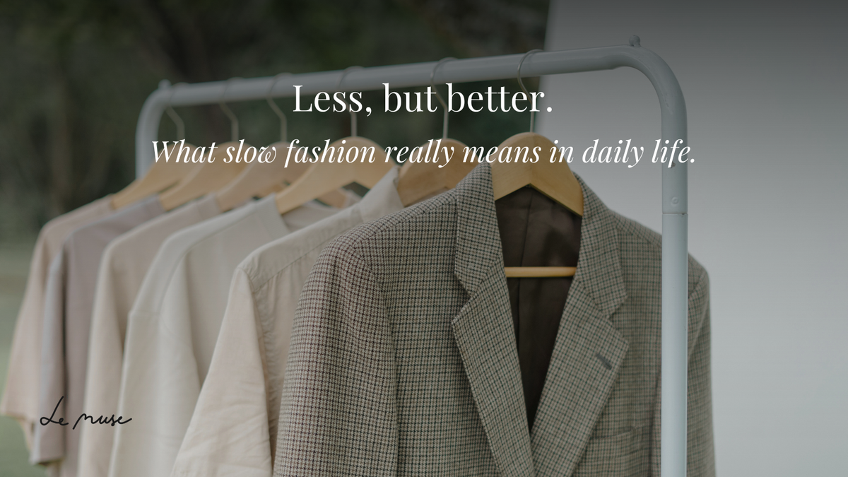 Hemden in neutralen Farben und ein Tweedblazer an einer Kleiderstange, "Less, but better."