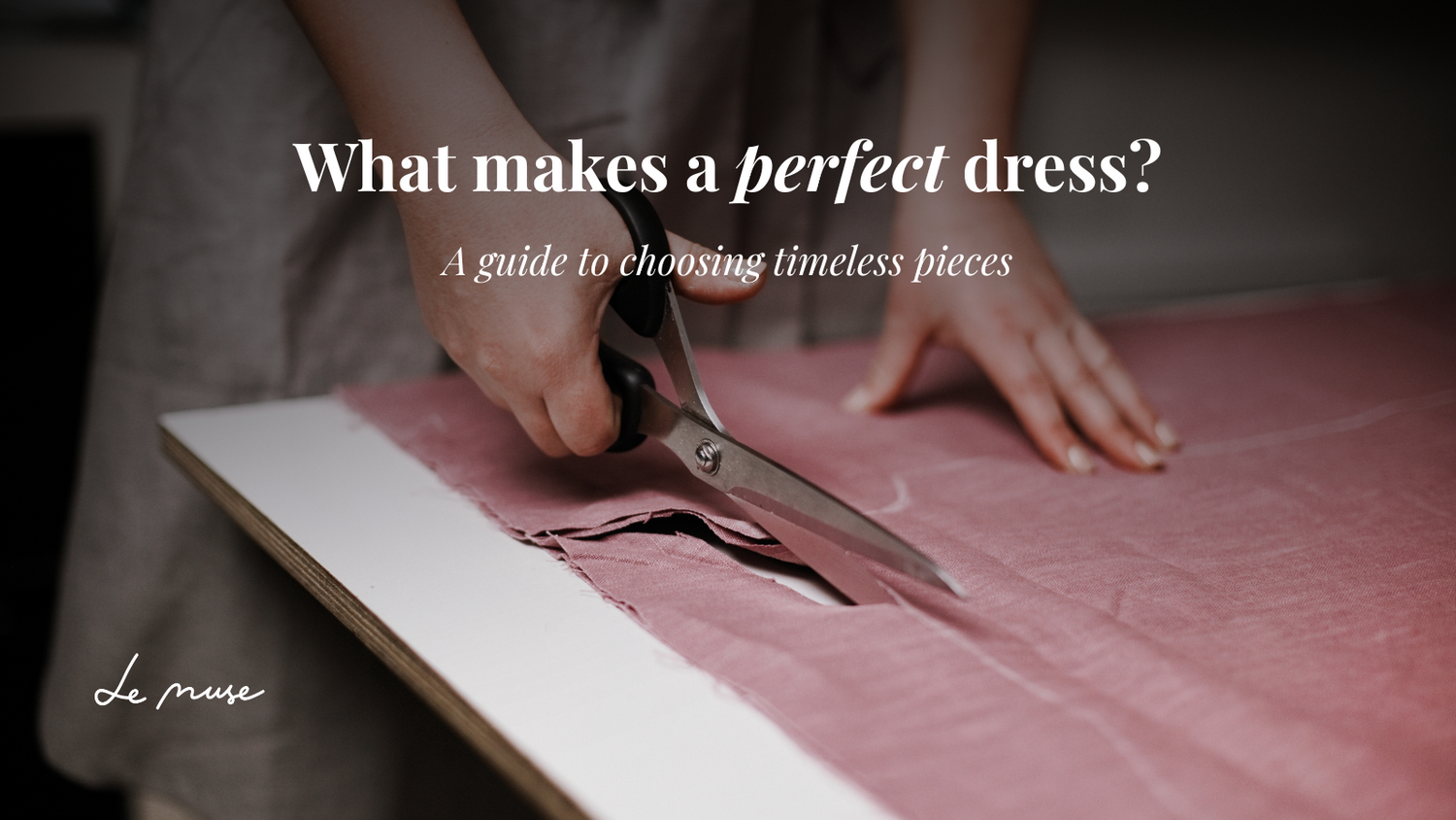 Rankos kerpa rožinį audinį žirklėmis po užrašu "What makes a perfect dress?"