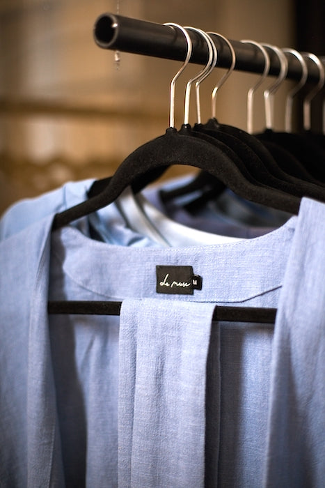 Light blue linen dress hanging on a clothes rail with LeMuse label