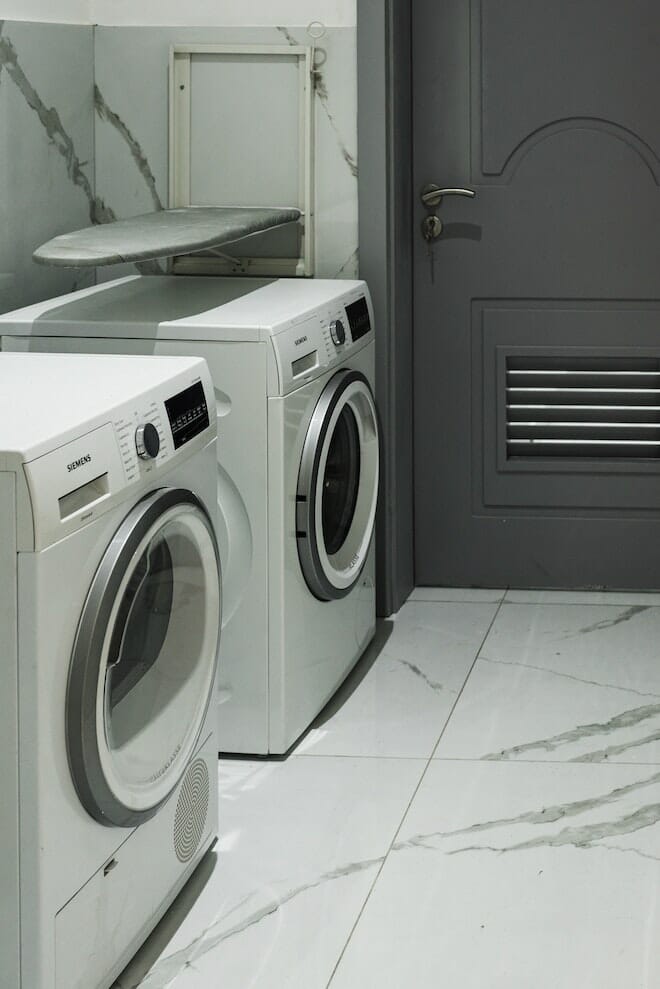 Washing machine and dryer in a white marble laundry room