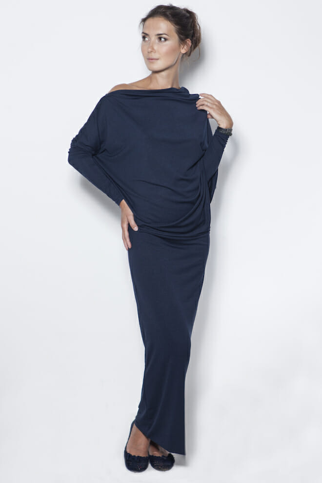 Frau in marineblauem drapiertem Off-Shoulder-Top und langem marineblauem Rock