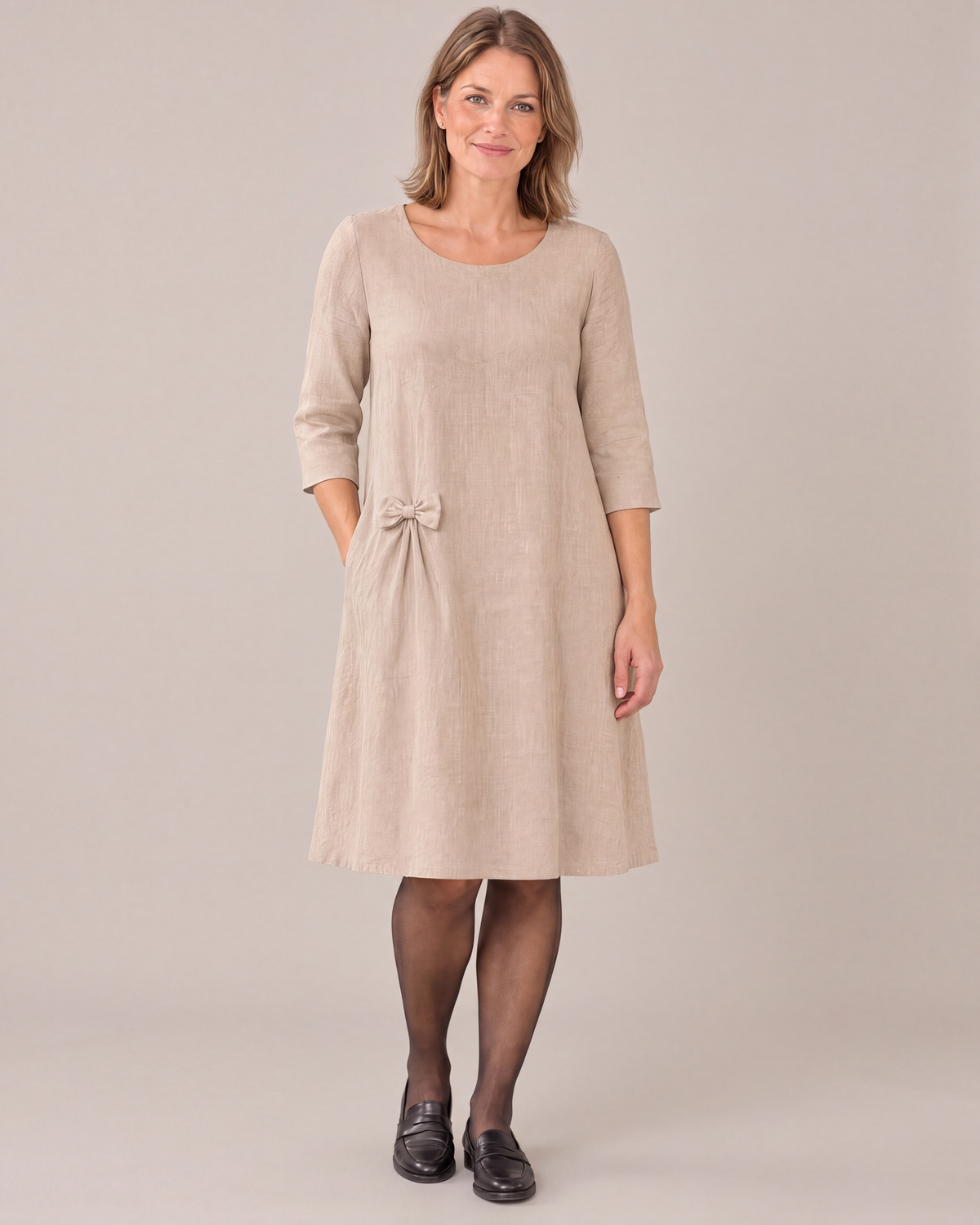 ADELE beige linen swing dress, front view with three-quarter sleeves and hip bow