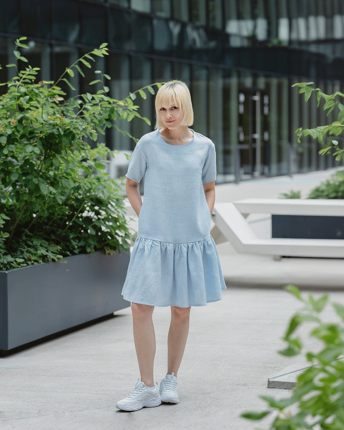 LeMuse BLOSSOM linen dress in light blue – front outdoors, hands in pockets #Color_Light blue