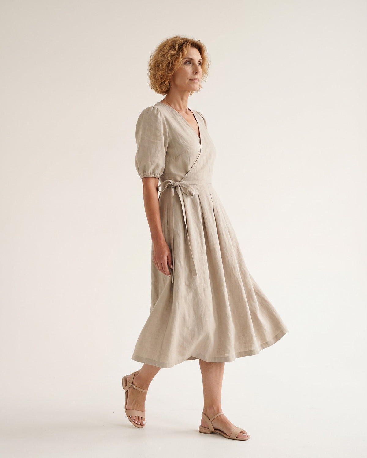 BONNIE – Linen Blend Puff Sleeve Tie-Waist Midi Dress – Beige suknelė, side view in motion, full length in studio #Color_Beige