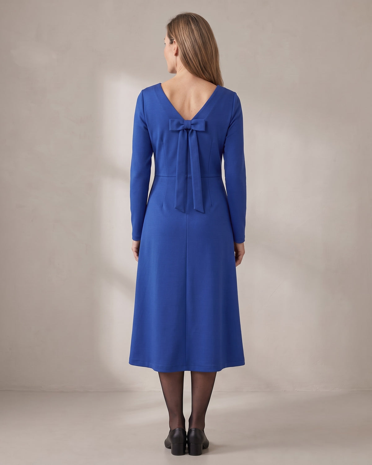 CLARA midi dress in Cobalt, back view with the bow, gentle A-line skirt