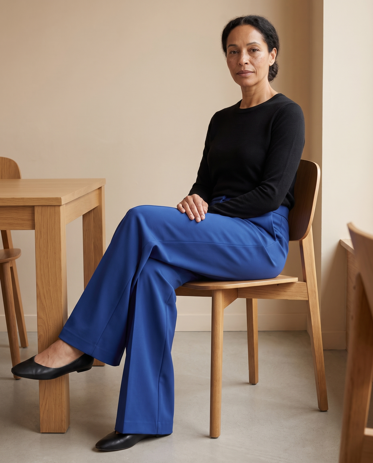 DORA cobalt trousers seated at a table