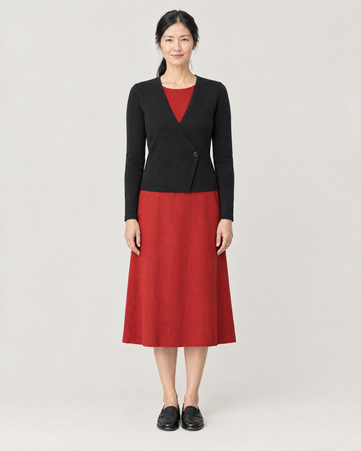 DRESS CARDIGAN black wool wrap cardigan over a red midi dress, front view