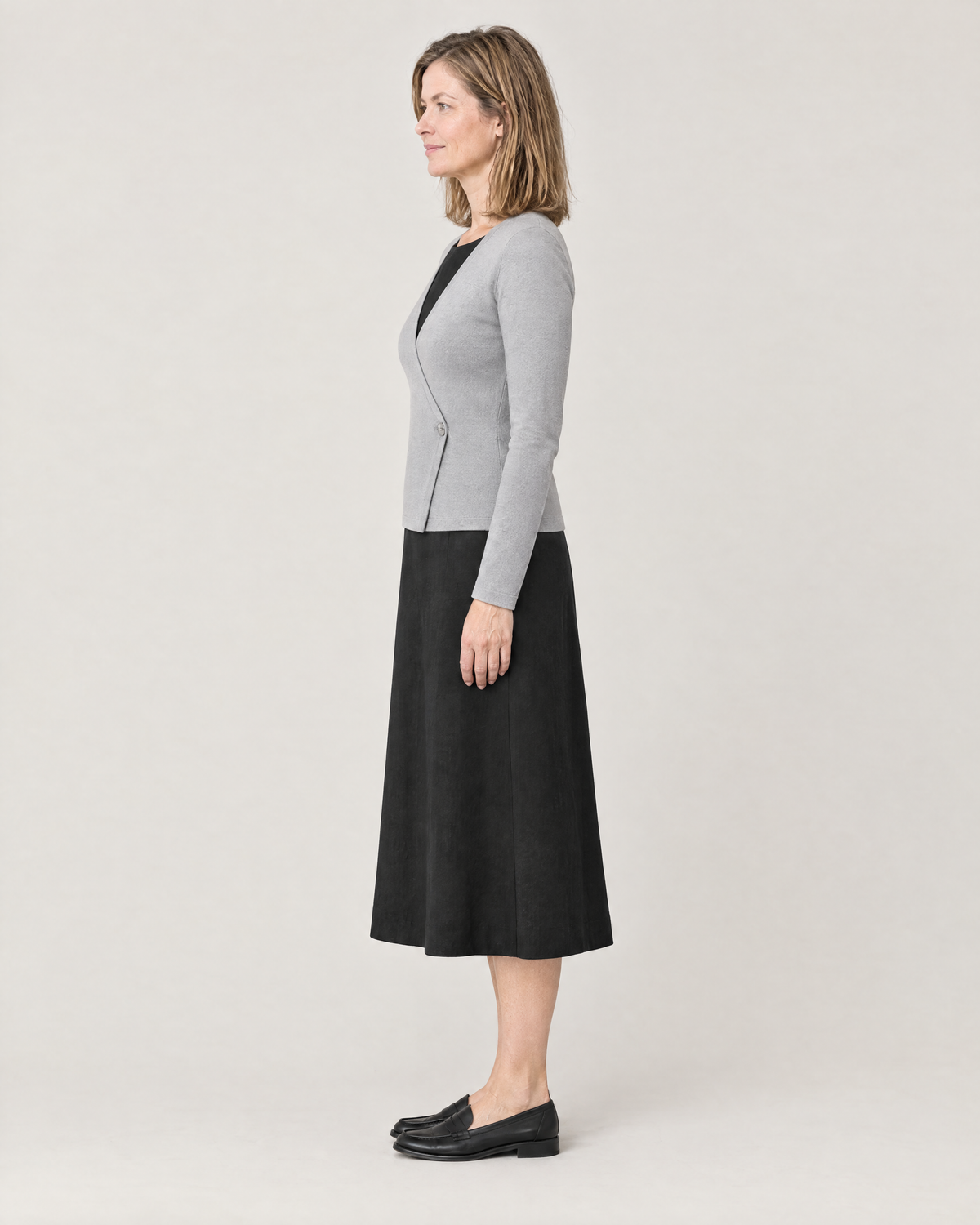 DRESS CARDIGAN light grey, side view showing the high-hip length over a midi dress