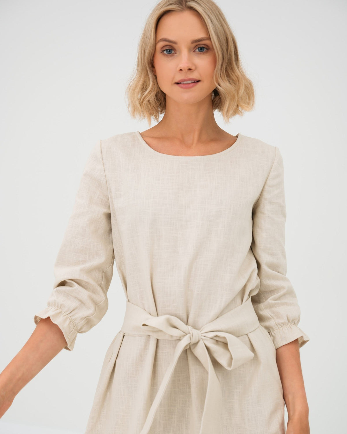 EMMA – Linen Blend Three-Quarter Sleeve Belted Dress – beige dress, studio front in motion with tie belt #Color_Beige