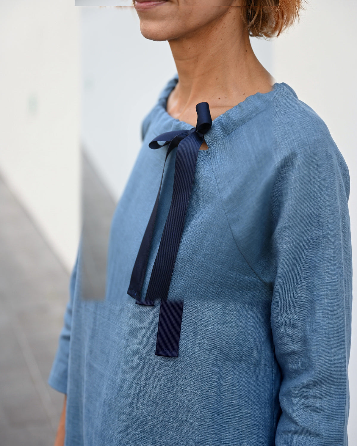 LeMuse FRENCH Leinenkleid in Blau – Detail des Ausschnitts mit Bandschleife