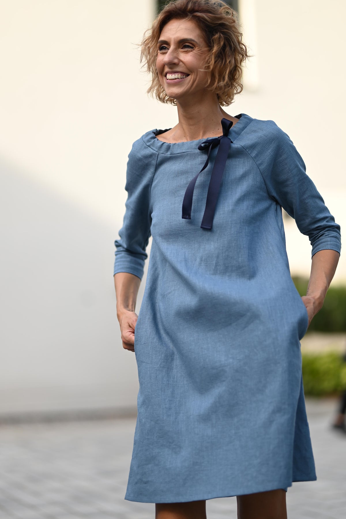 LeMuse FRENCH linen dress in blue – model smiling in motion #Color_Blue