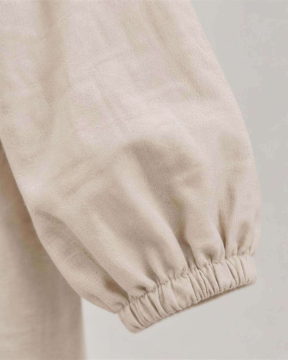 Close-up of light beige linen fabric texture and sleeve cuff detail on a midi dress. #Color_Beige