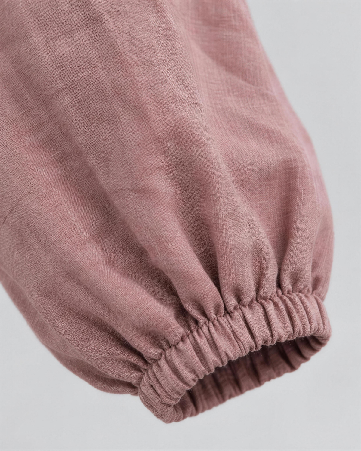 Close-up of dusty rose linen fabric texture and sleeve cuff detail on a midi dress. #Color_Dusty rose