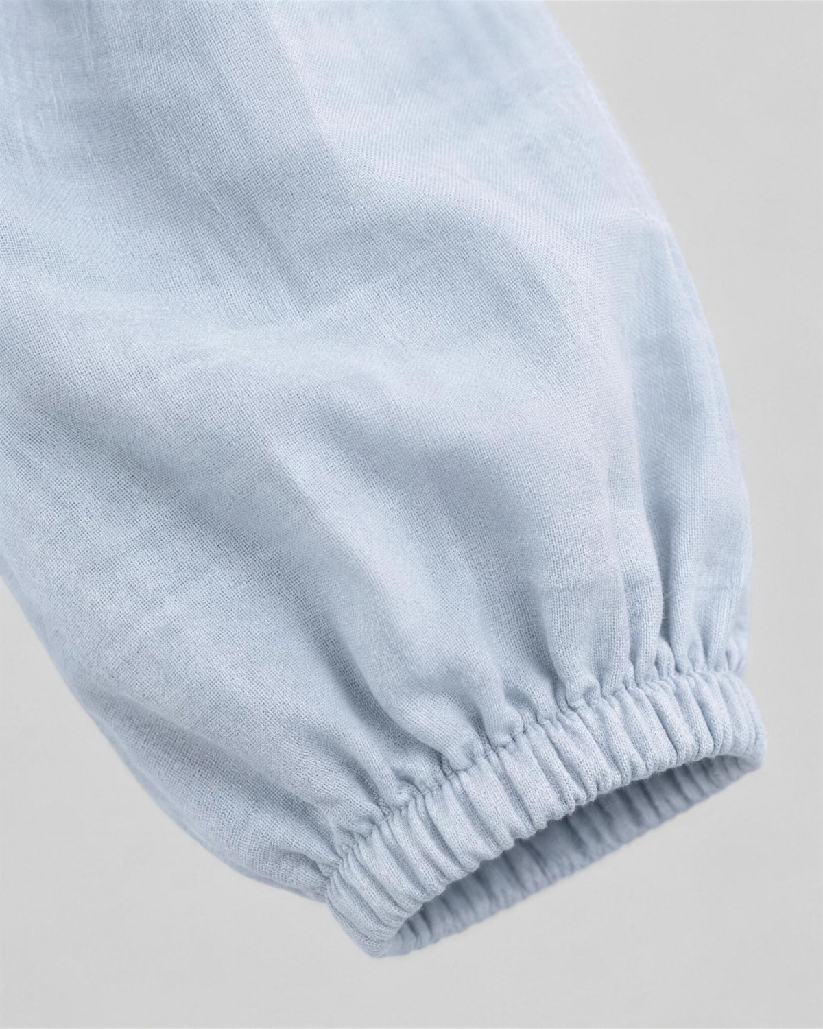Close-up of pale light blue linen fabric texture and sleeve cuff detail on a midi dress. #Color_Light blue