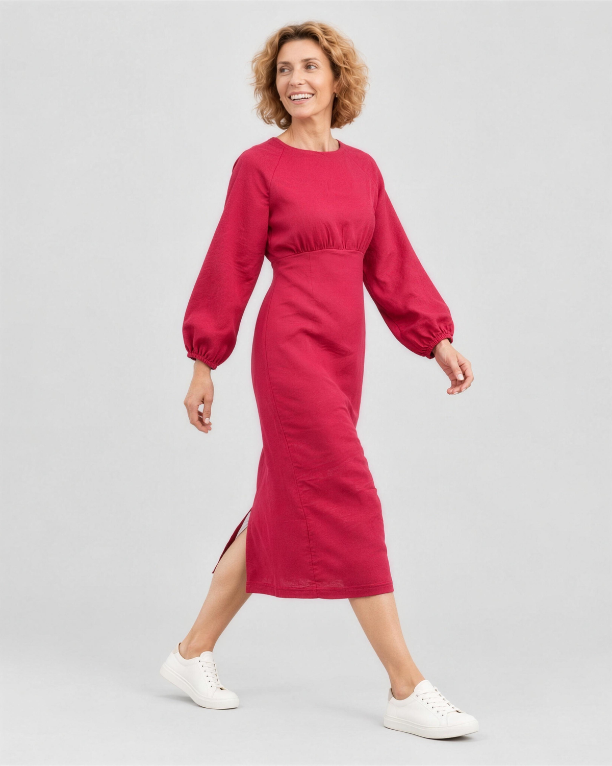A woman walking, side view, wearing a bright cerise red-pink linen midi dress, showing how the linen fabric moves. #Color_Cerise