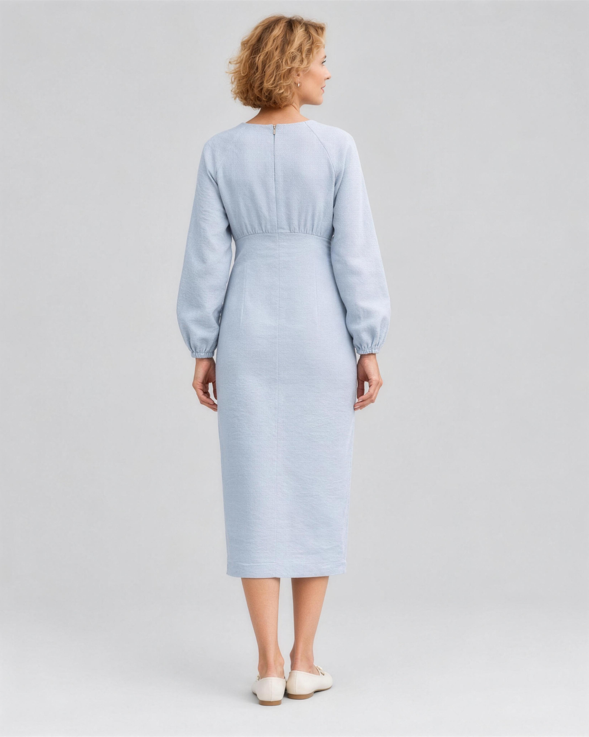 A woman viewed from the back in a studio, wearing a pale light blue linen midi dress with a gathered waist, full length. #Color_Light blue
