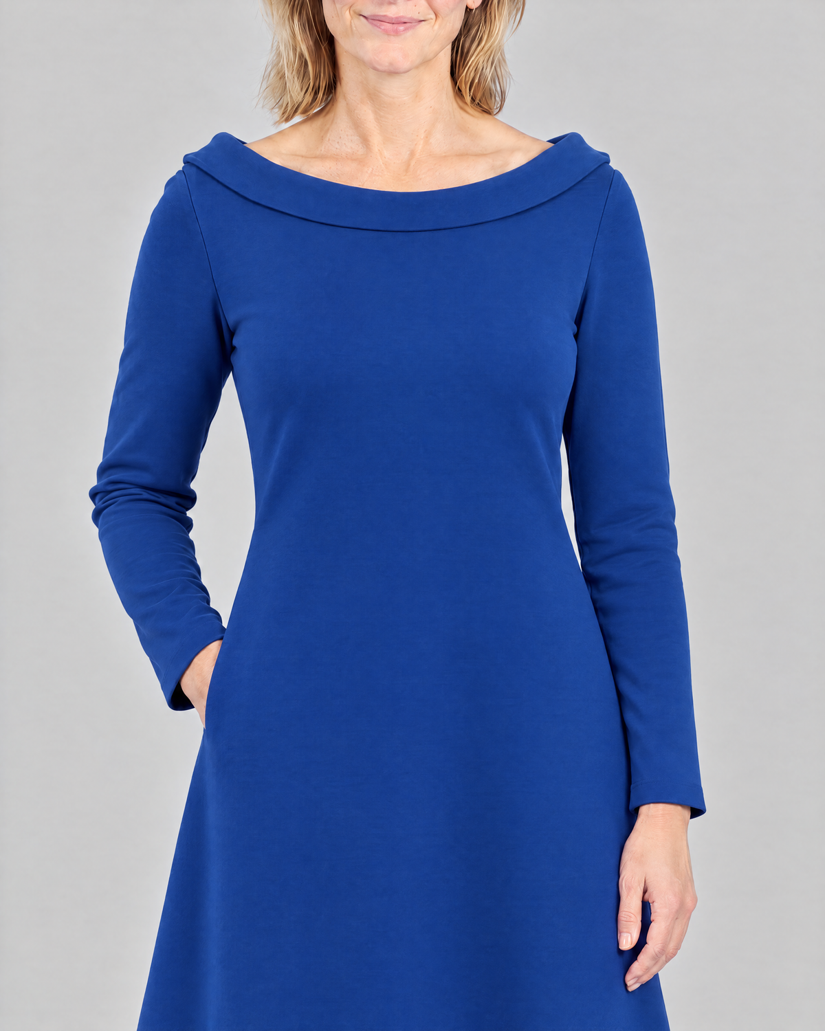 STORY TALL Punto – cobalt dress detail: doubled portrait collar, hand in side-seam pocket, sleeve to the wrist
