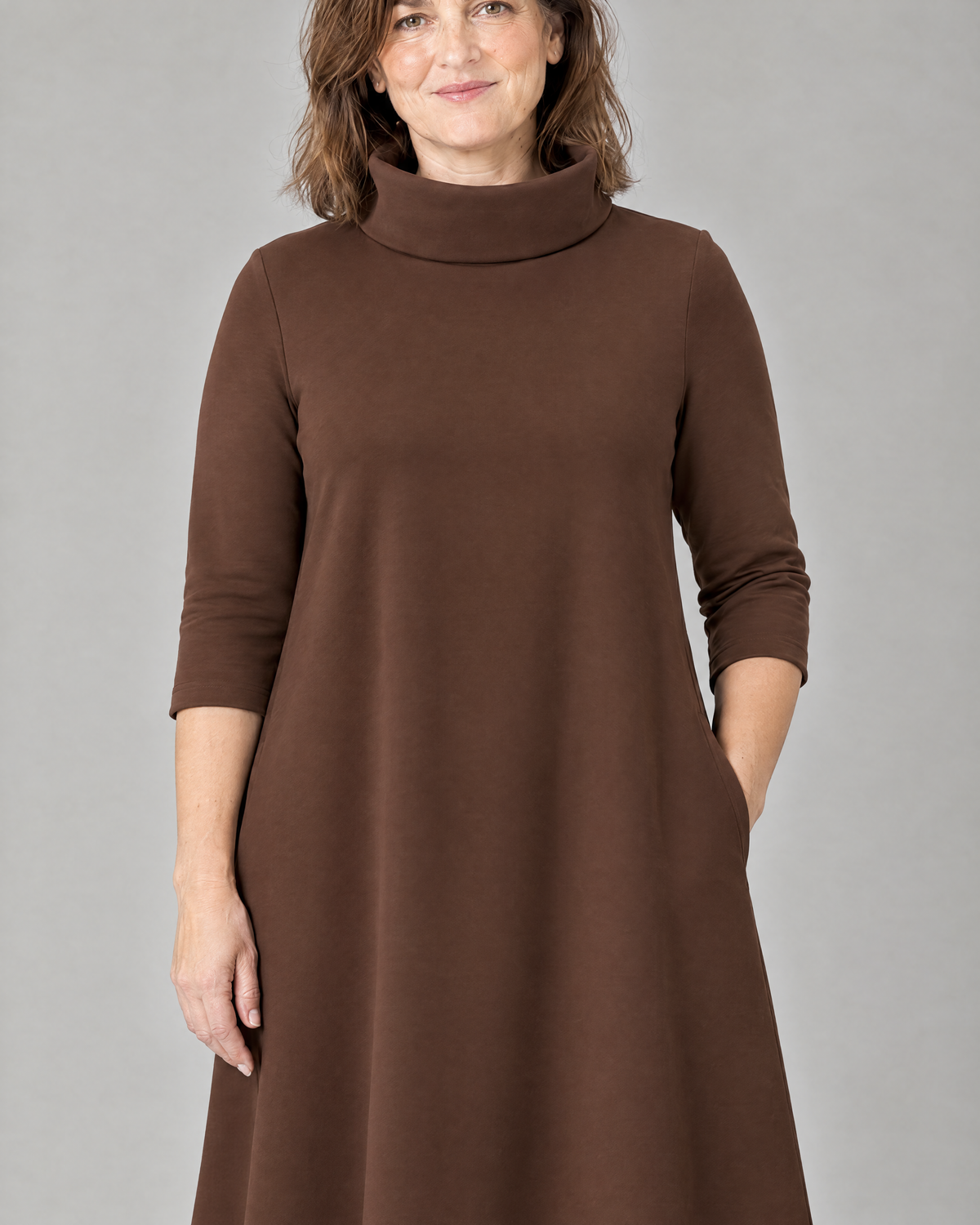KIND A-line midi dress in Brown, close-up of the funnel collar, 3/4 sleeve and side pocket in smooth Punto knit