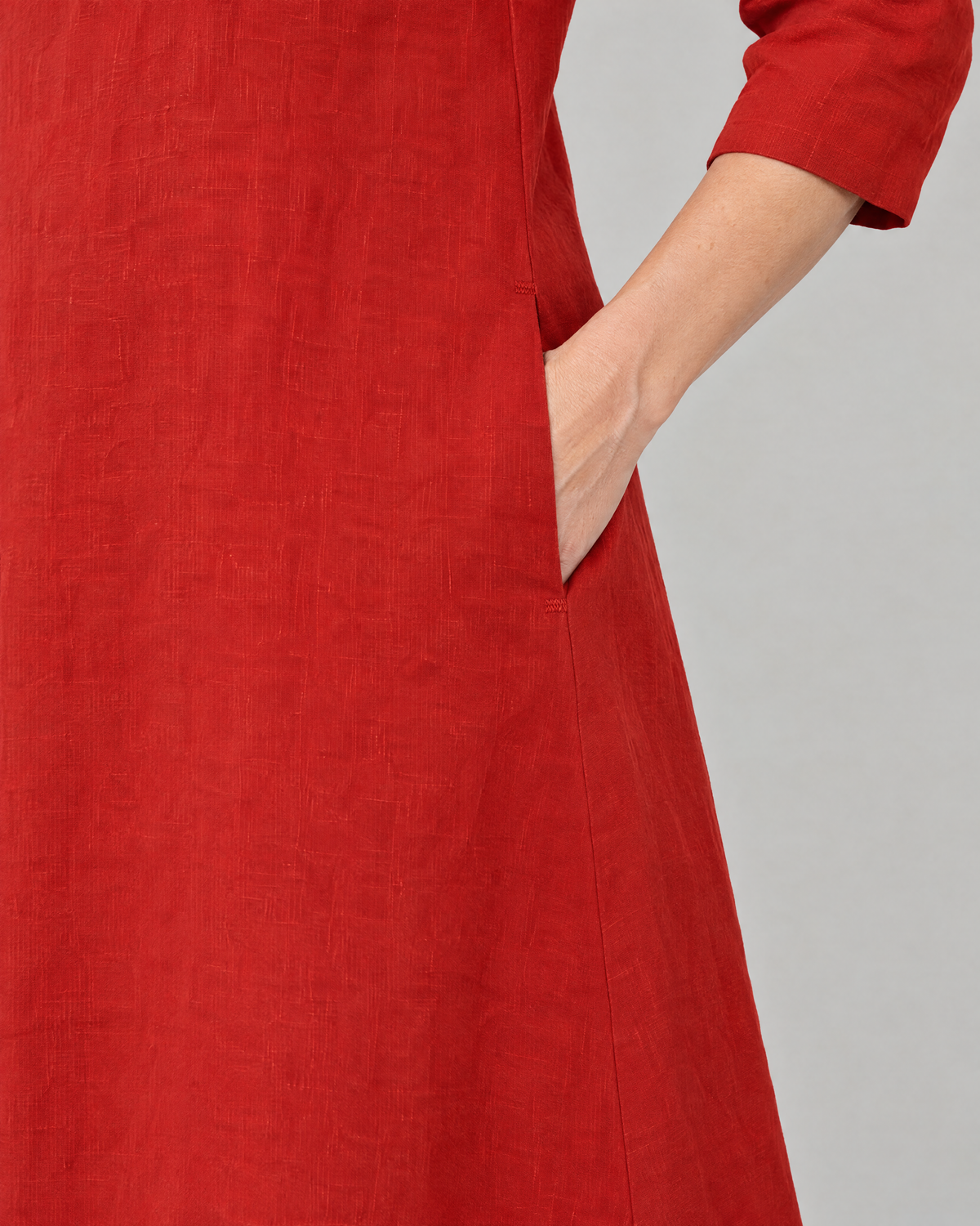 Close-up of the BASE side-seam pocket with reinforced bartacks in red linen