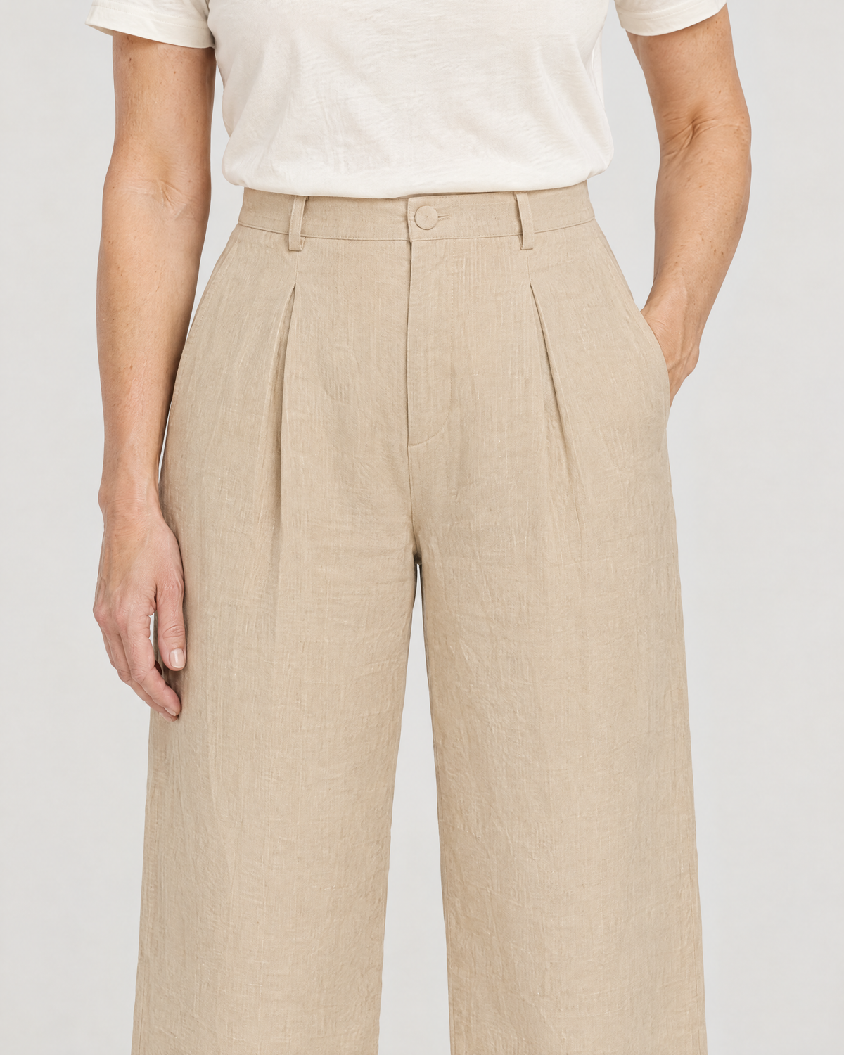 Close-up of the LYRA OPAQUE waistband, belt loops, self-covered button, front pleat and side pocket in beige linen