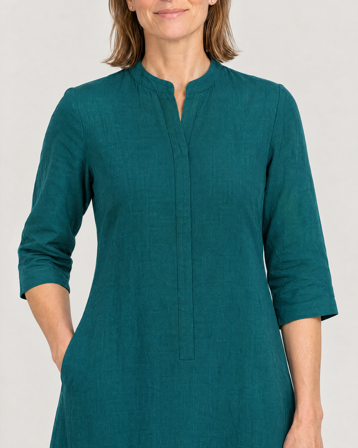Close-up of the SUMMER COLOUR stand collar, concealed placket and side-seam pocket in teal linen