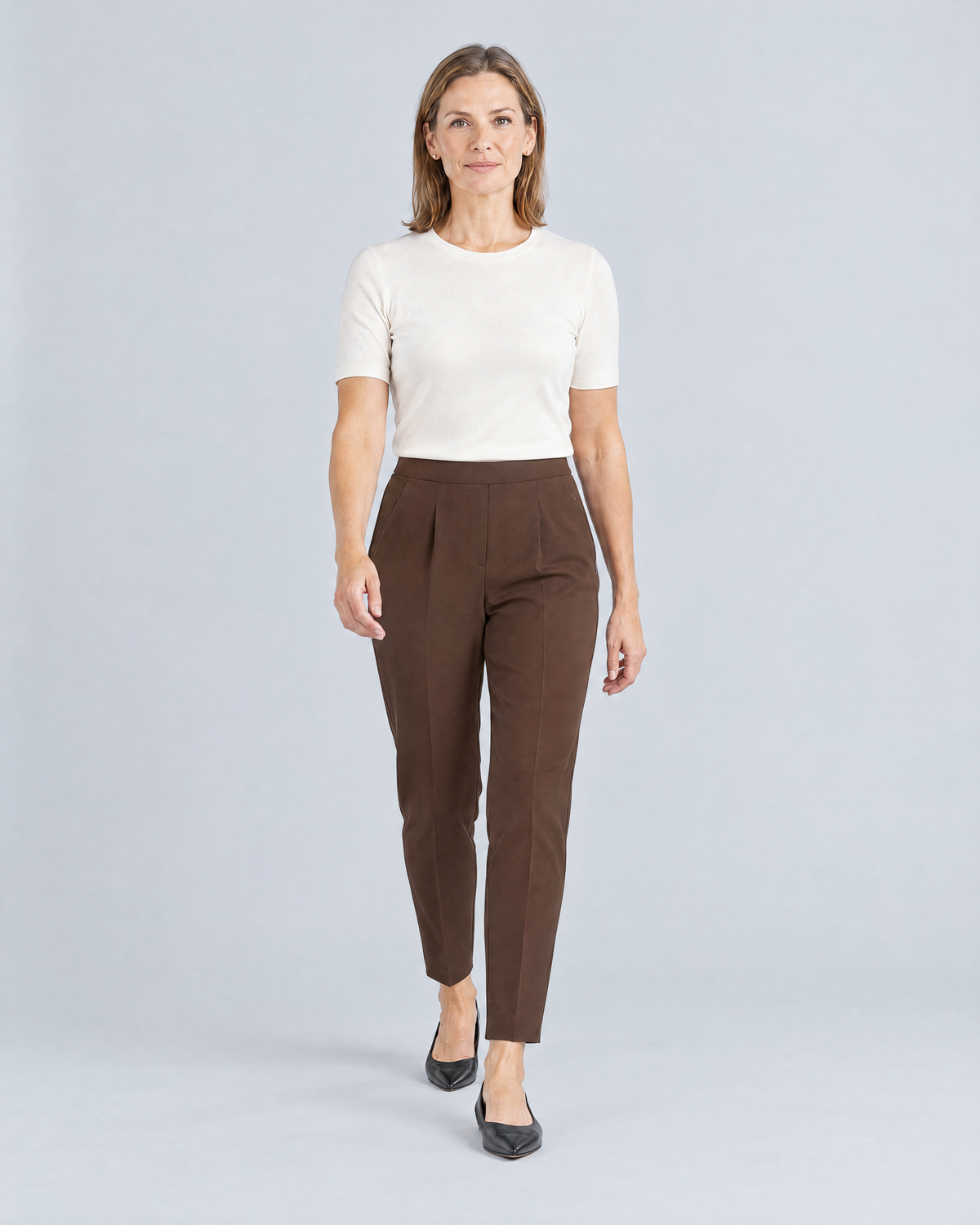 Woman walking in SIT WELL brown tapered trousers