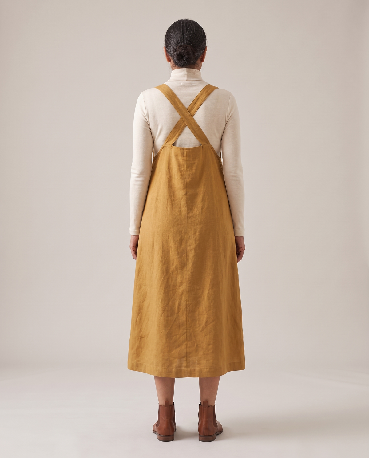 LAYER linen pinafore dress in Ochre, back view with crossed straps