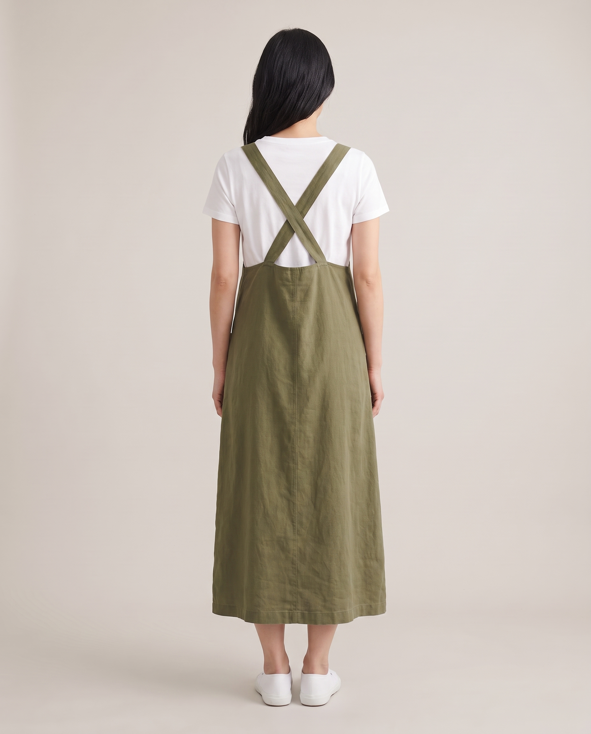 LAYER linen pinafore dress in Olive Green, back view with crossed straps