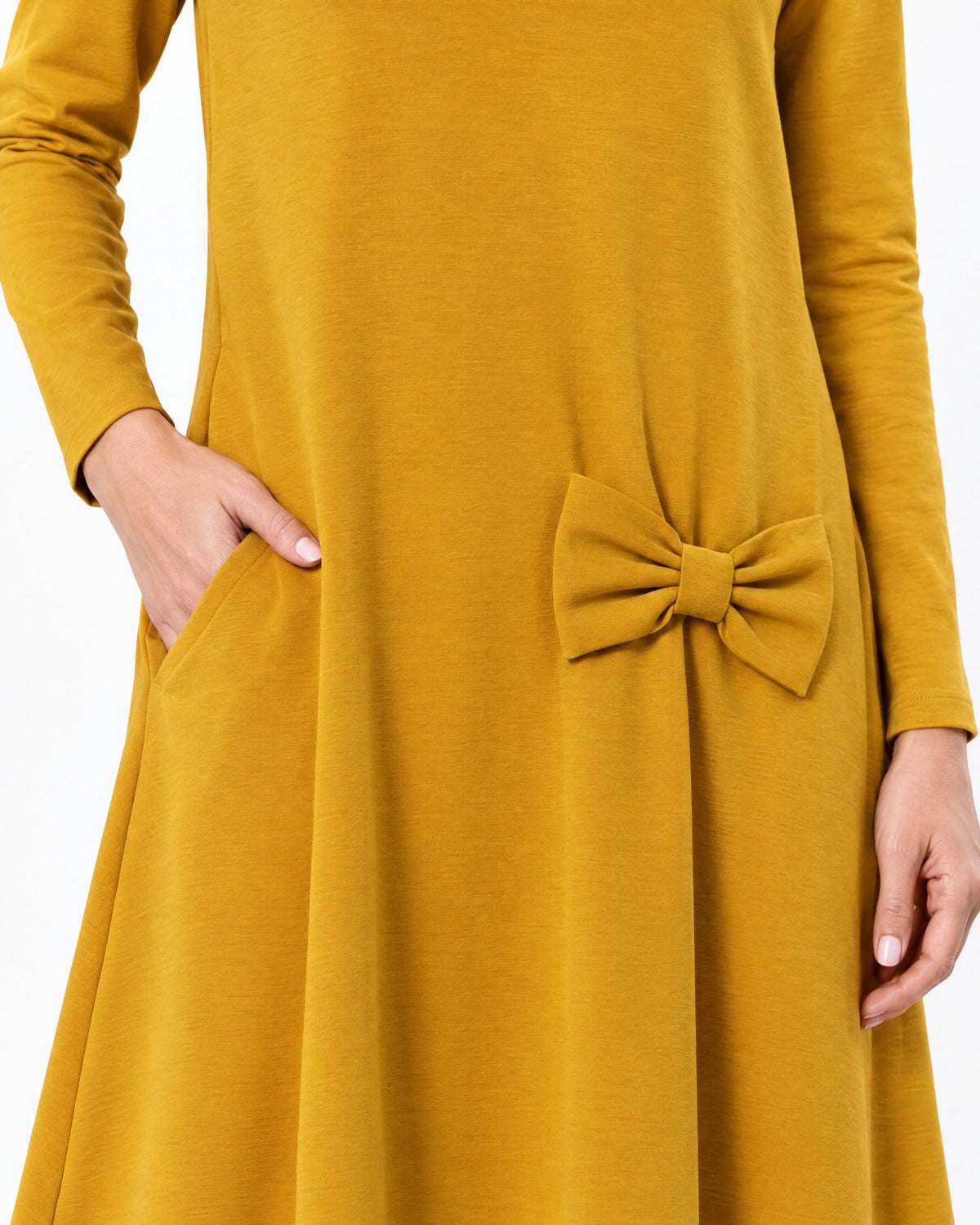 Close-up of a mustard yellow long-sleeve A-line dress showing the side pocket, bow detail and Punto Milano knit fabric texture. #Color_Yellow