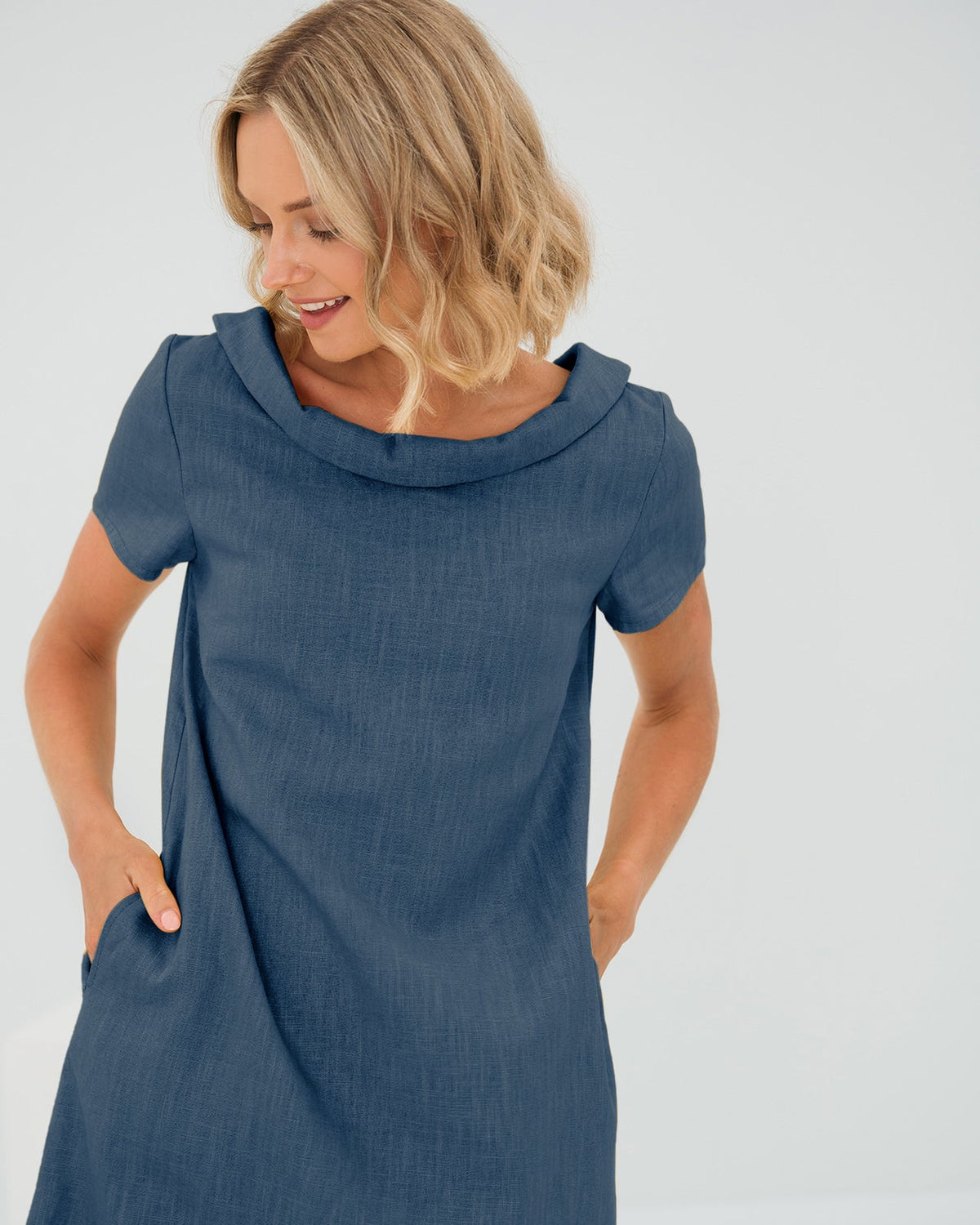 LeMuse STORY linen dress in blue – studio front view, hands in pockets #Color_Blue