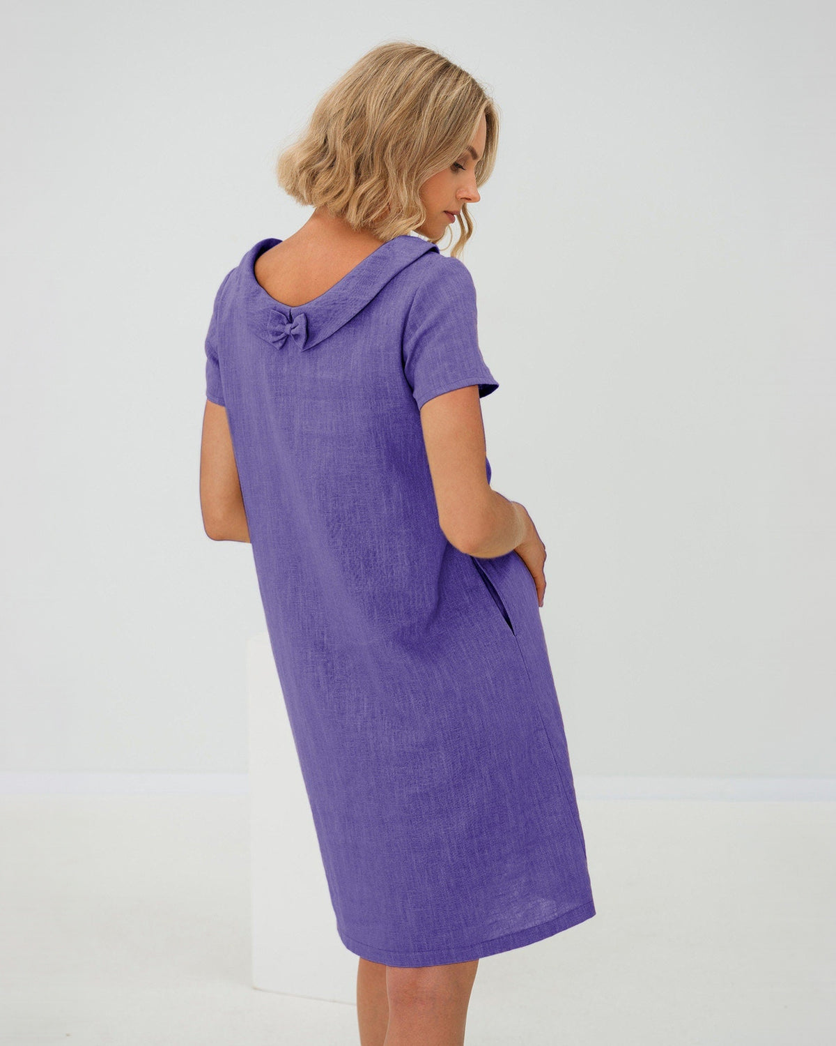 LeMuse STORY linen dress in purple – studio three-quarter back view with neck bow #Color_Purple