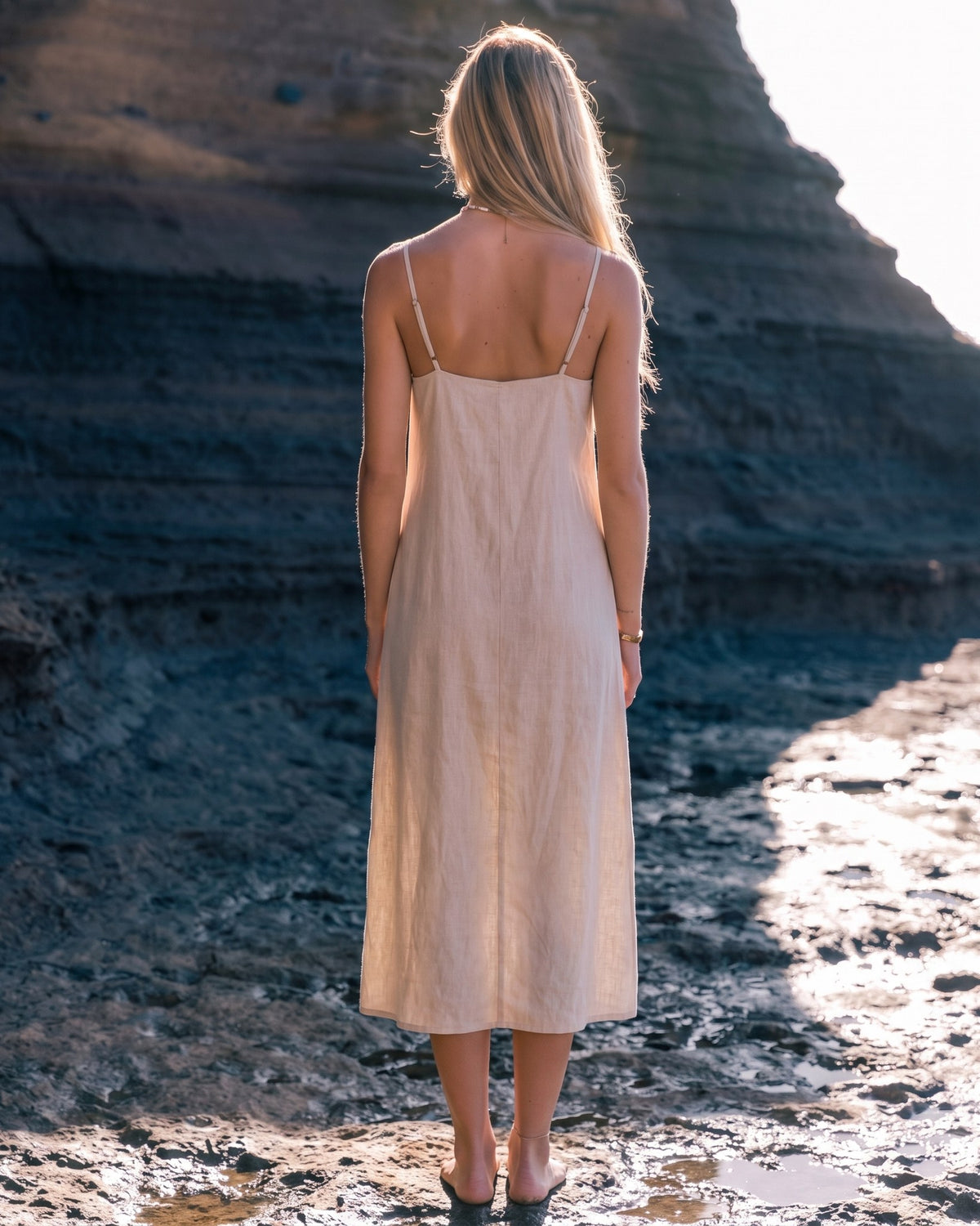 LeMuse SUNSET linen dress in beige – model back view full length by the cliffs #Color_Beige