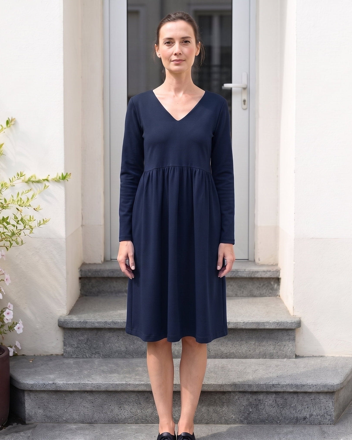 Woman wearing SUNSHINE Punto Milano midi dress in deep blue, lifestyle photo on stone steps #Color_Deep blue