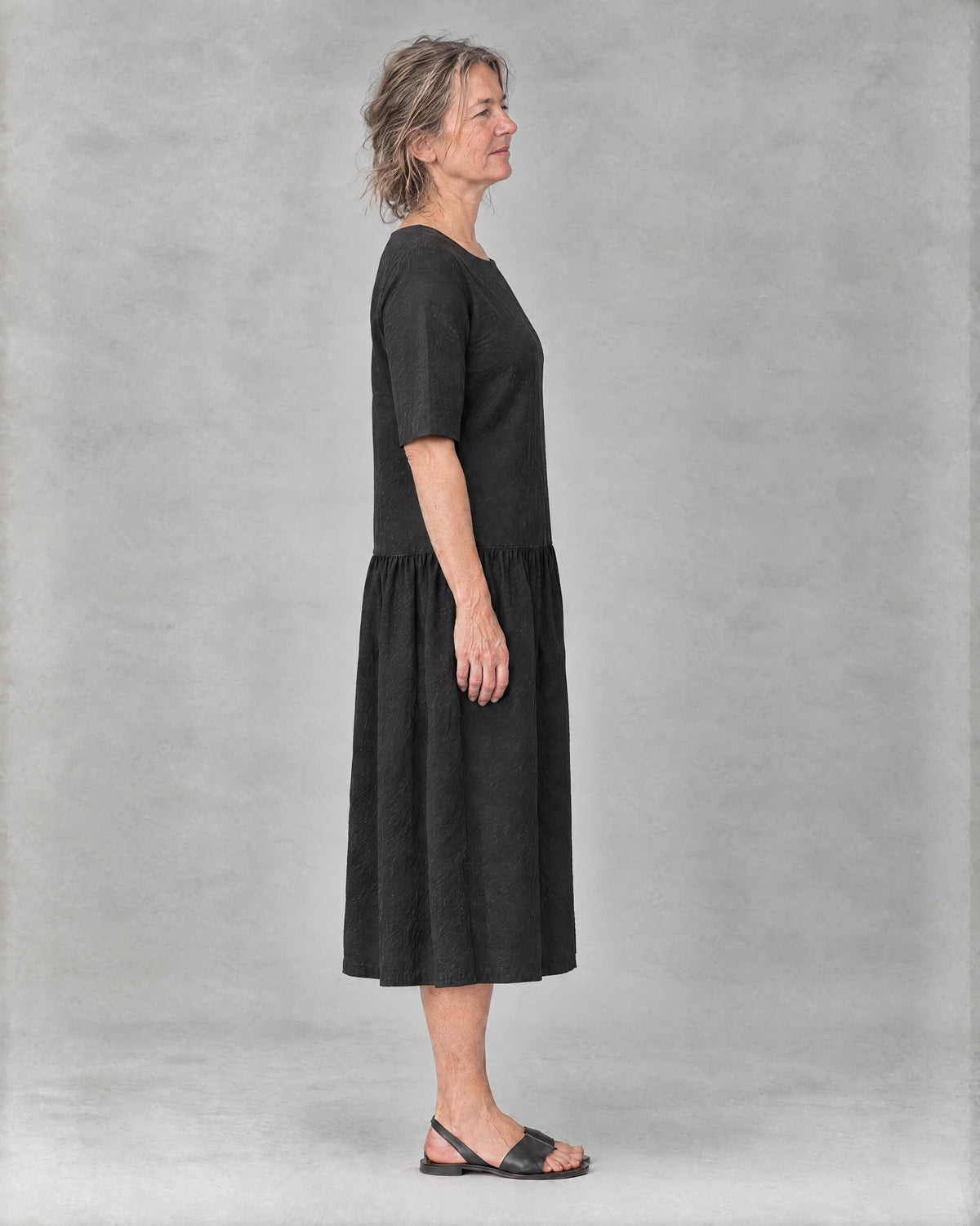 TESSA black linen tiered midi dress, side view with elbow-length sleeve