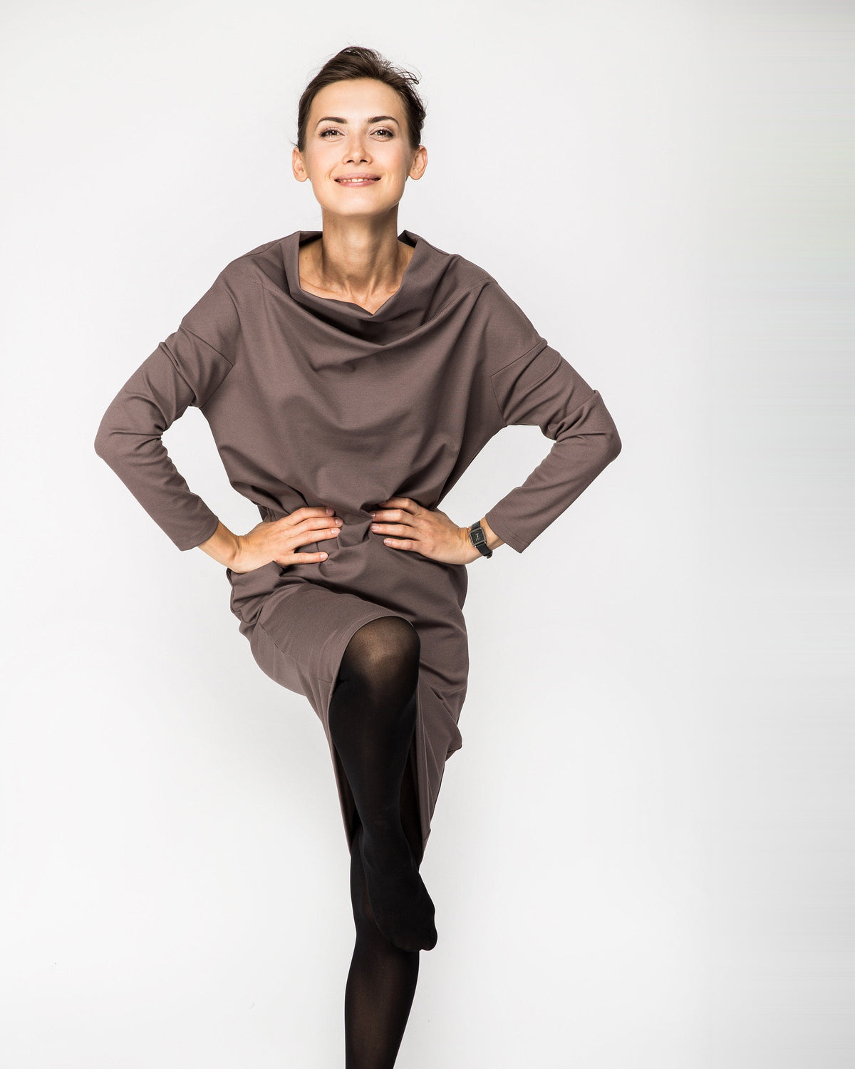 A woman wearing a taupe brown long-sleeve cowl-neck midi dress with side pockets, movement pose. #Color_Cacao