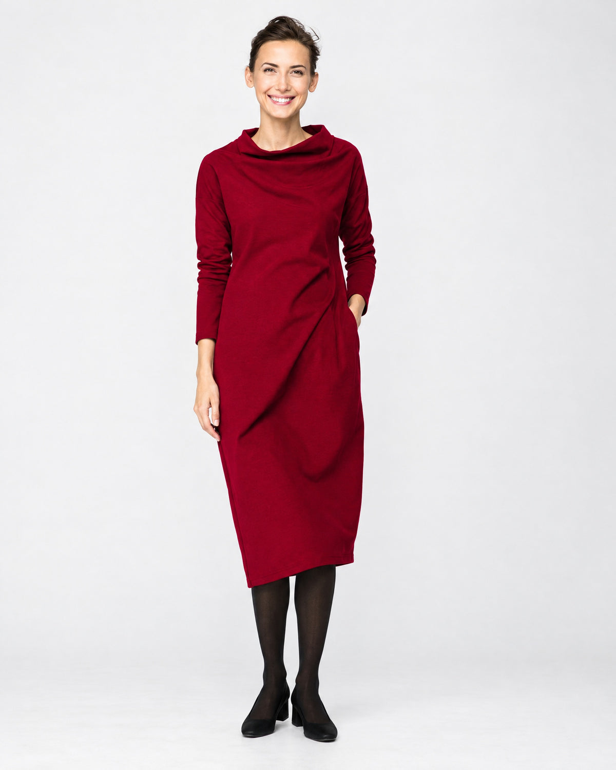 A woman wearing a dark red long-sleeve cowl-neck midi dress with side pockets, full-length front view with shoes, studio background. #Color_Red