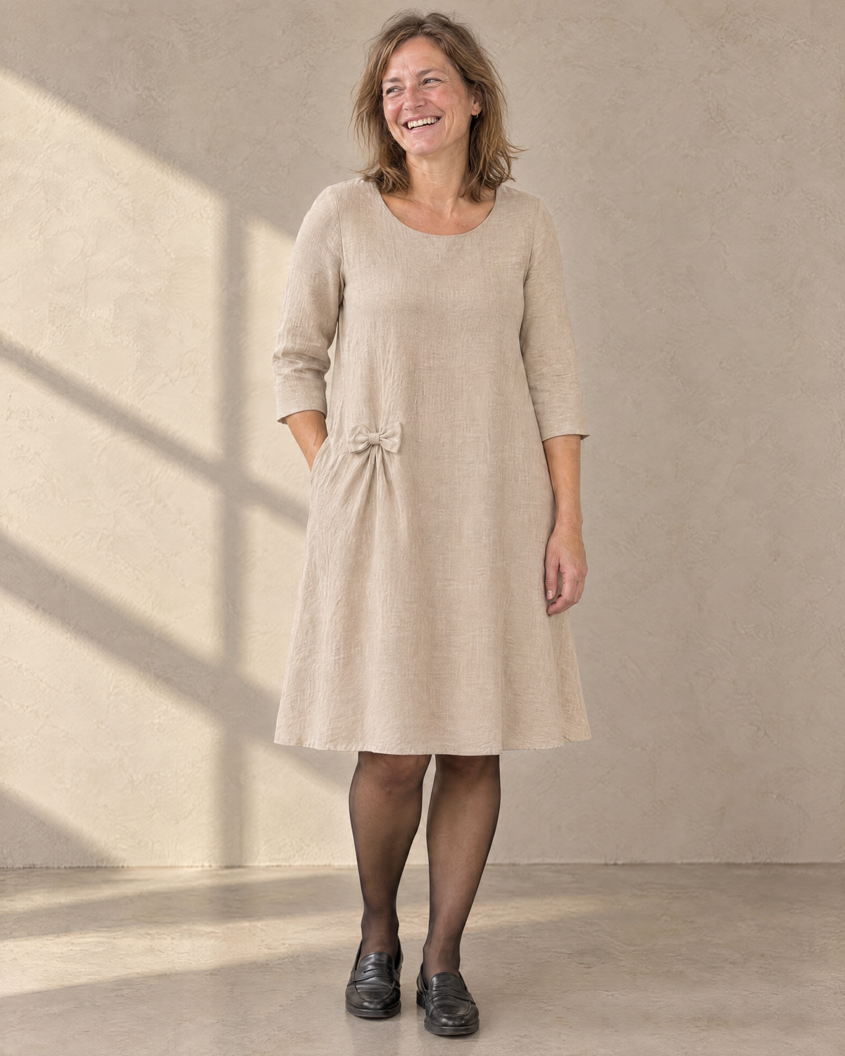 ADELE beige linen swing dress, front view with three-quarter sleeves and hip bow