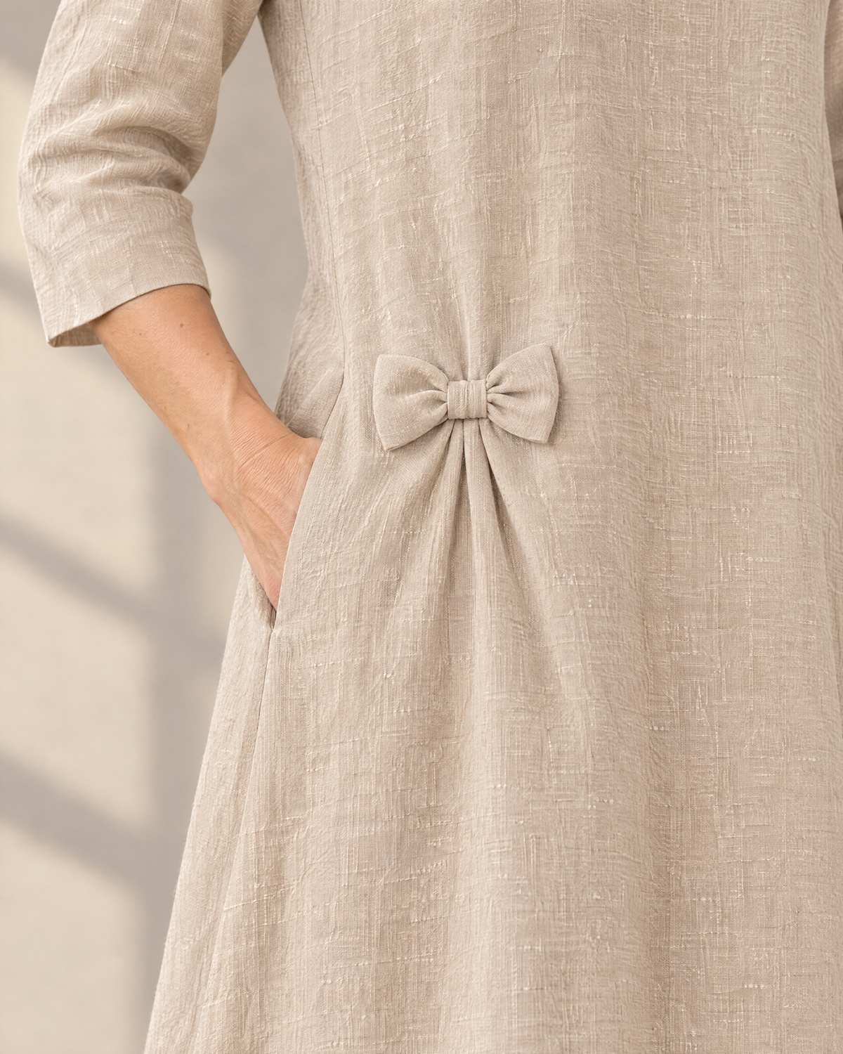 ADELE detail: small linen hip bow, soft tucks and side-seam pocket