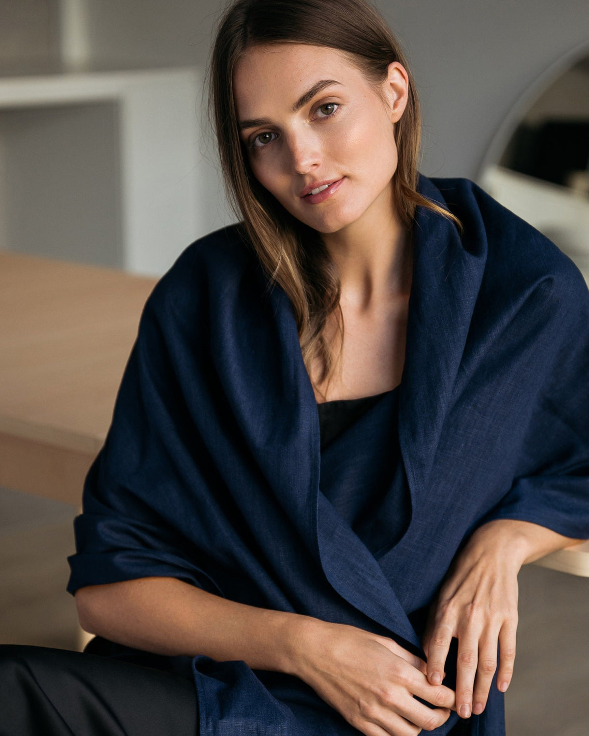 A navy blue linen scarf wrapped around the shoulders, fringed edge detail. #Color_Deep blue
