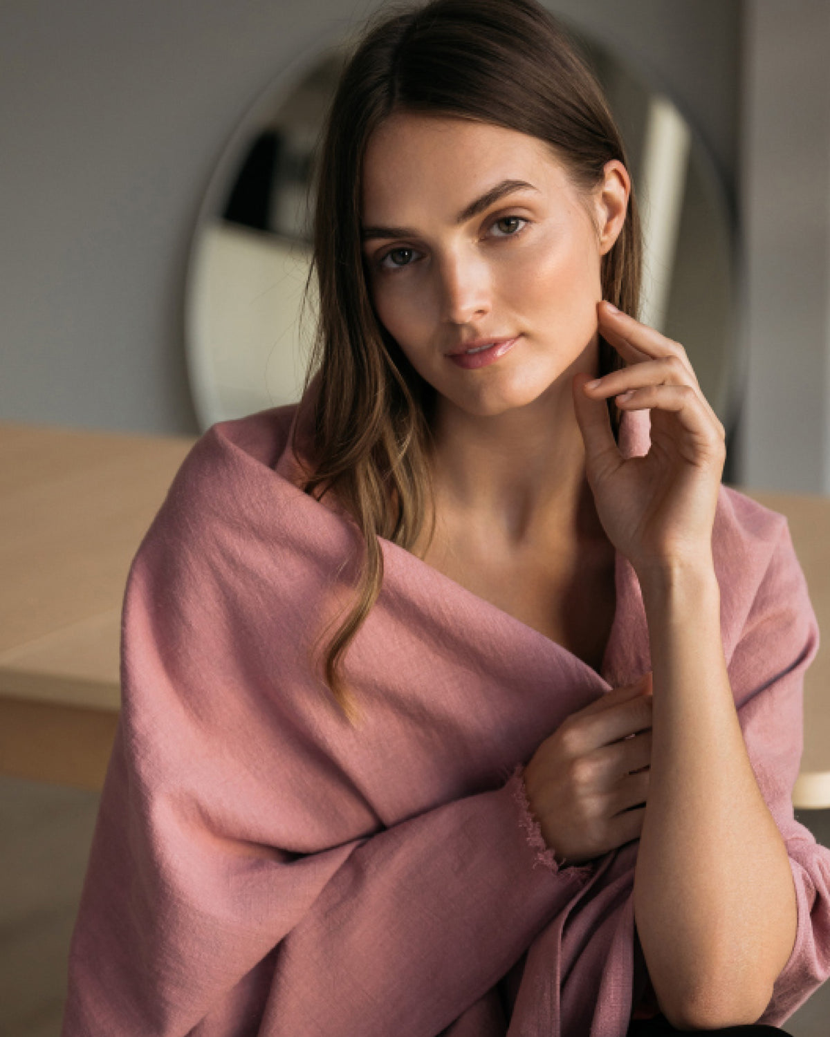 A dusty rose linen scarf wrapped around the shoulders, fringed edge detail. #Color_Dusty rose