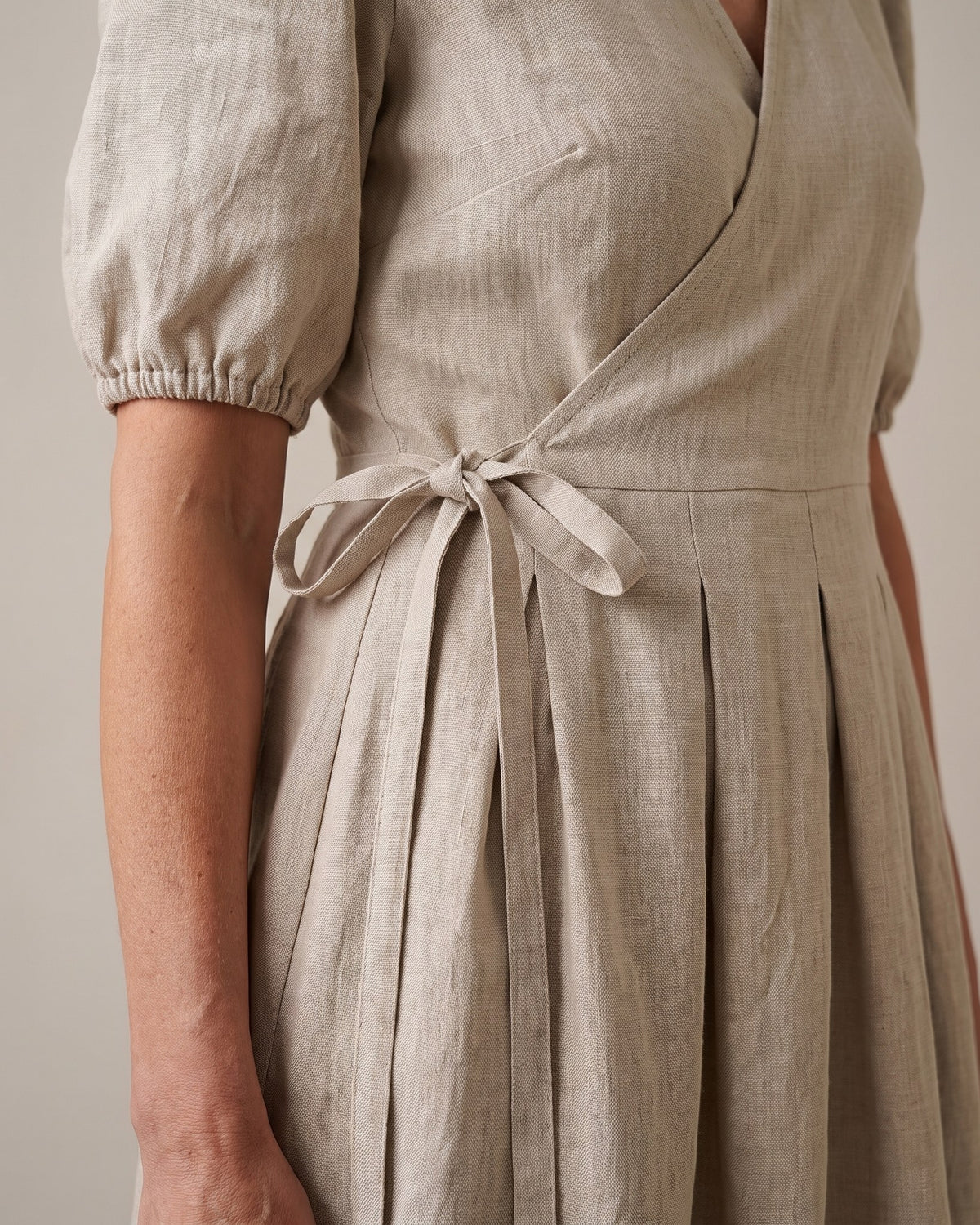BONNIE – Linen Blend Puff Sleeve Tie-Waist Midi Dress – Beige suknelė, close-up of the tie-waist knot, pleated skirt and puff sleeve cuff #Color_Beige