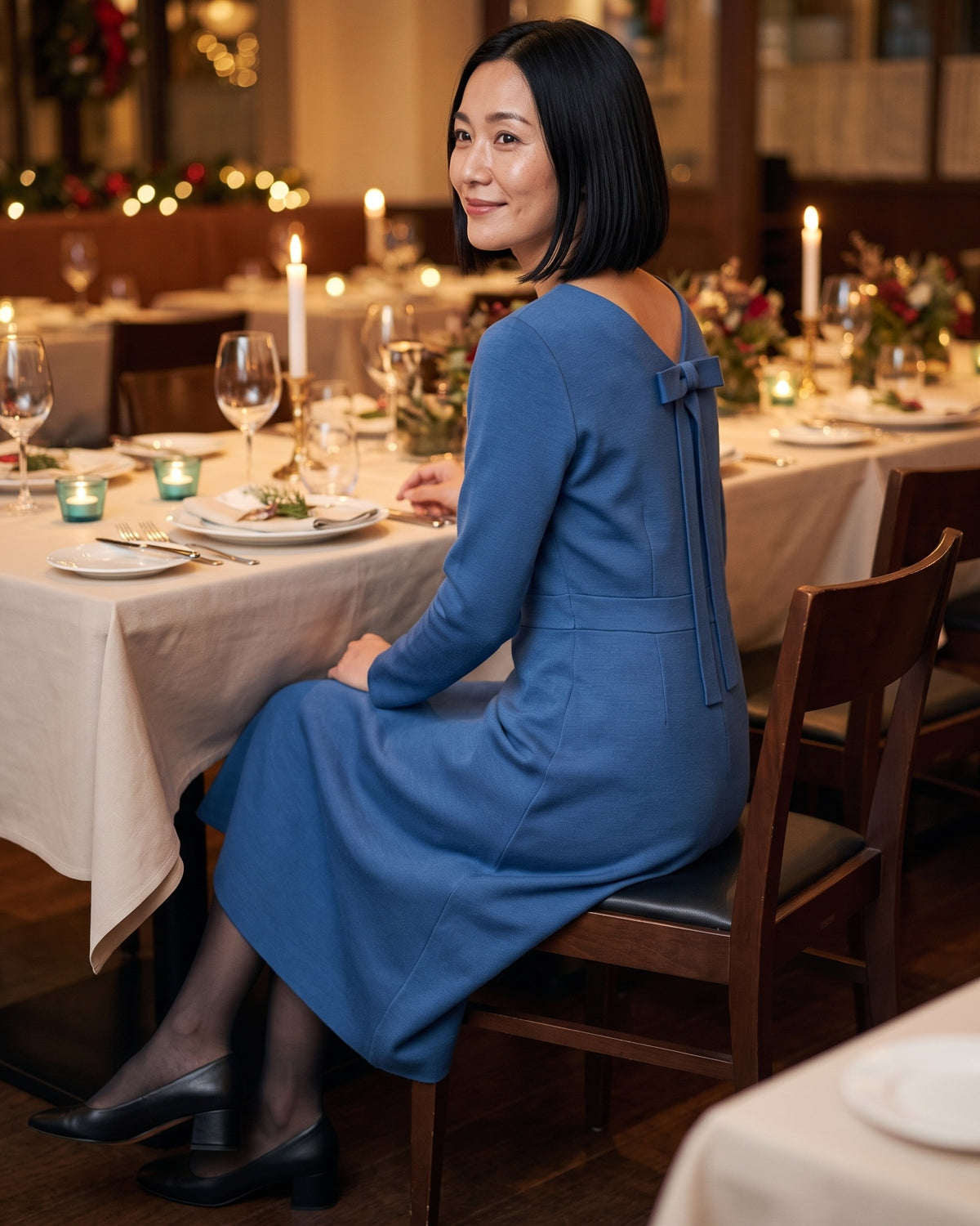 CLARA midi dress in Blue at a dinner table, back bow visible