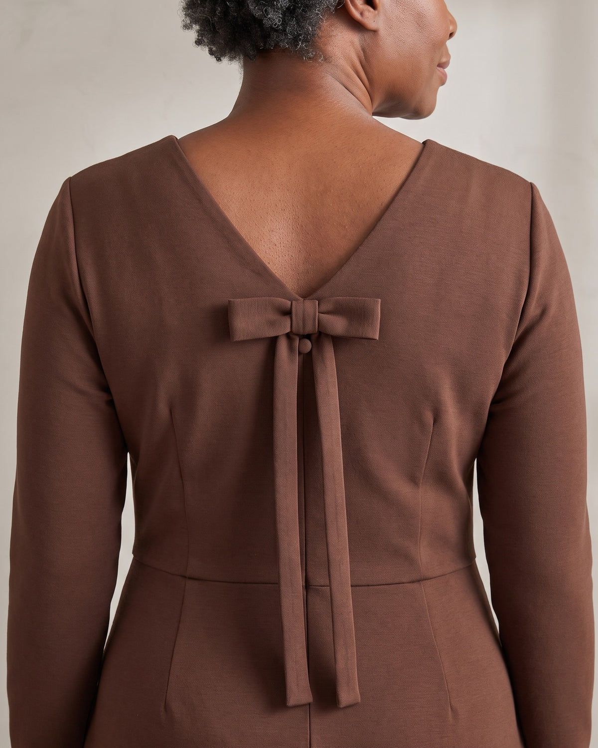 CLARA back bow detail in Brown with the button under the knot