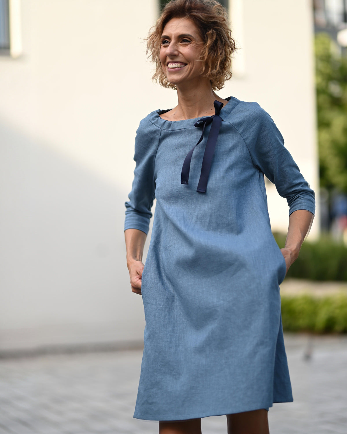LeMuse FRENCH Leinenkleid in Blau – lächelndes Model in Bewegung