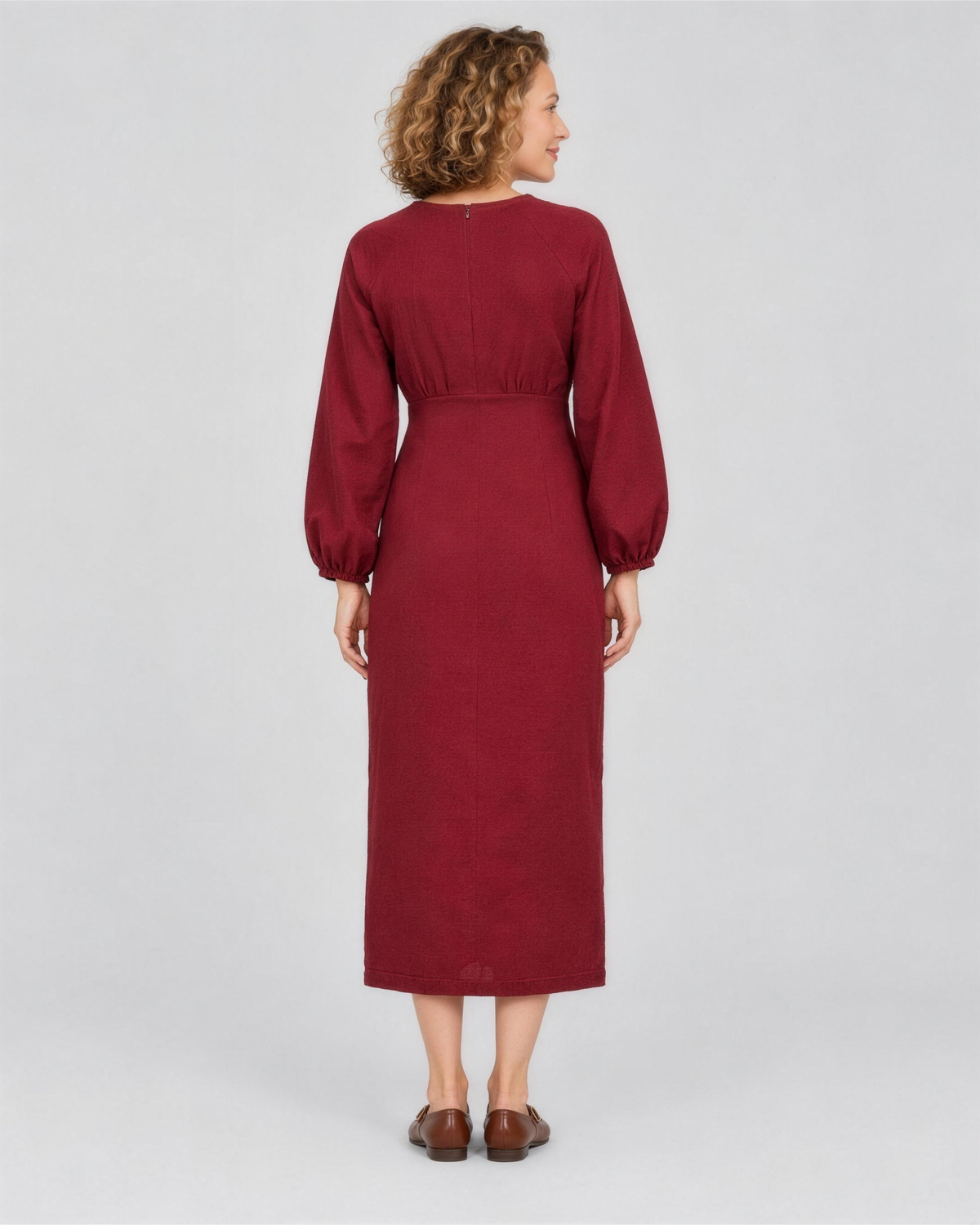 A woman viewed from the back in a studio, wearing a deep burgundy linen midi dress with a gathered waist, full length. #Color_Burgundy