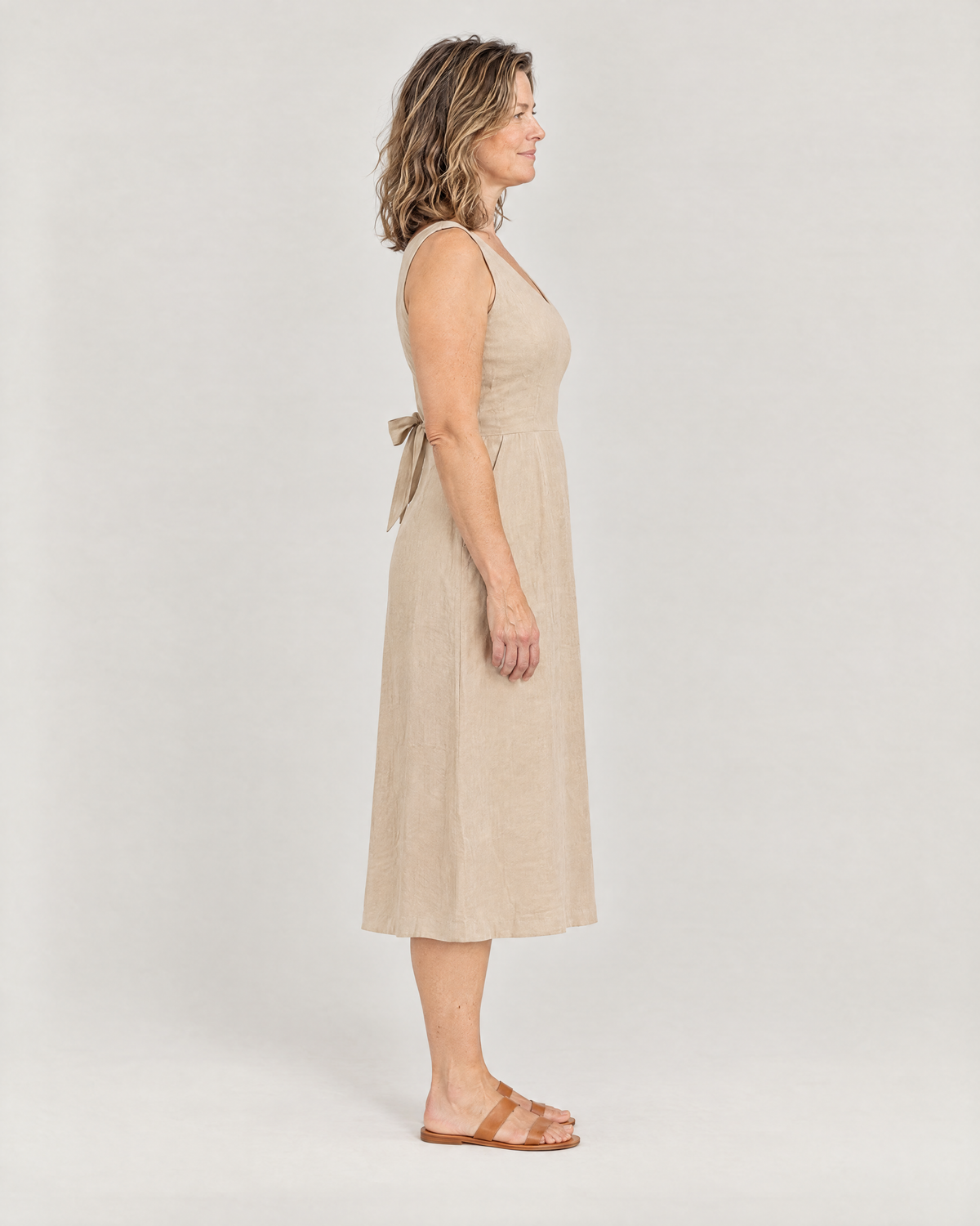 DAYLIGHT beige linen midi dress, side view with ties at the waist and gentle A-line skirt