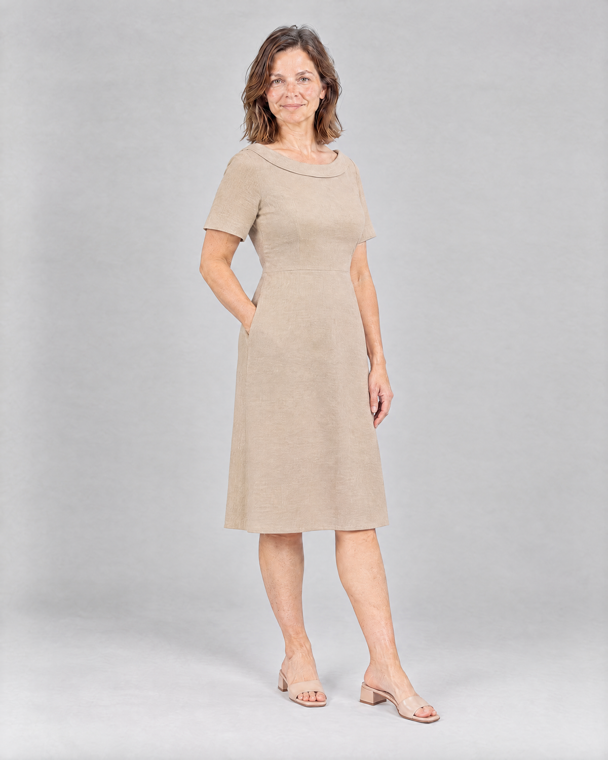 STORY PETITE Beige linen dress, three-quarter view with hand in side pocket