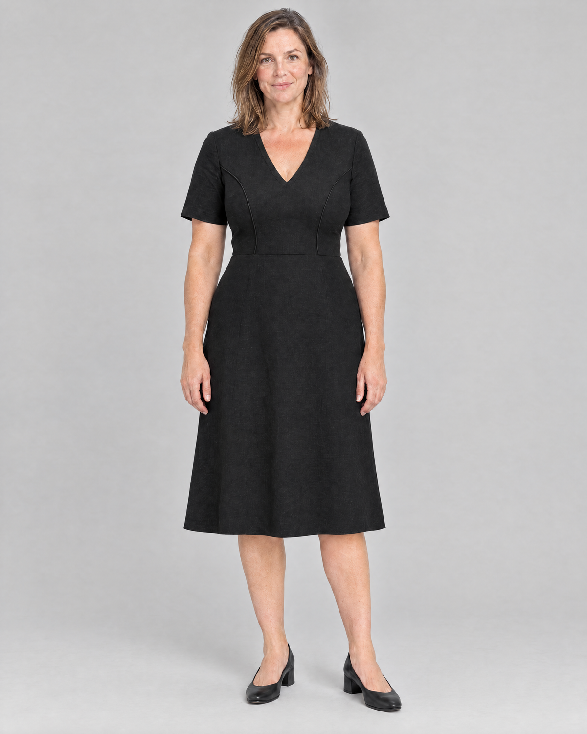 ROOM black Dutch linen V-neck A-line midi dress with short sleeves and piped princess seams, front view