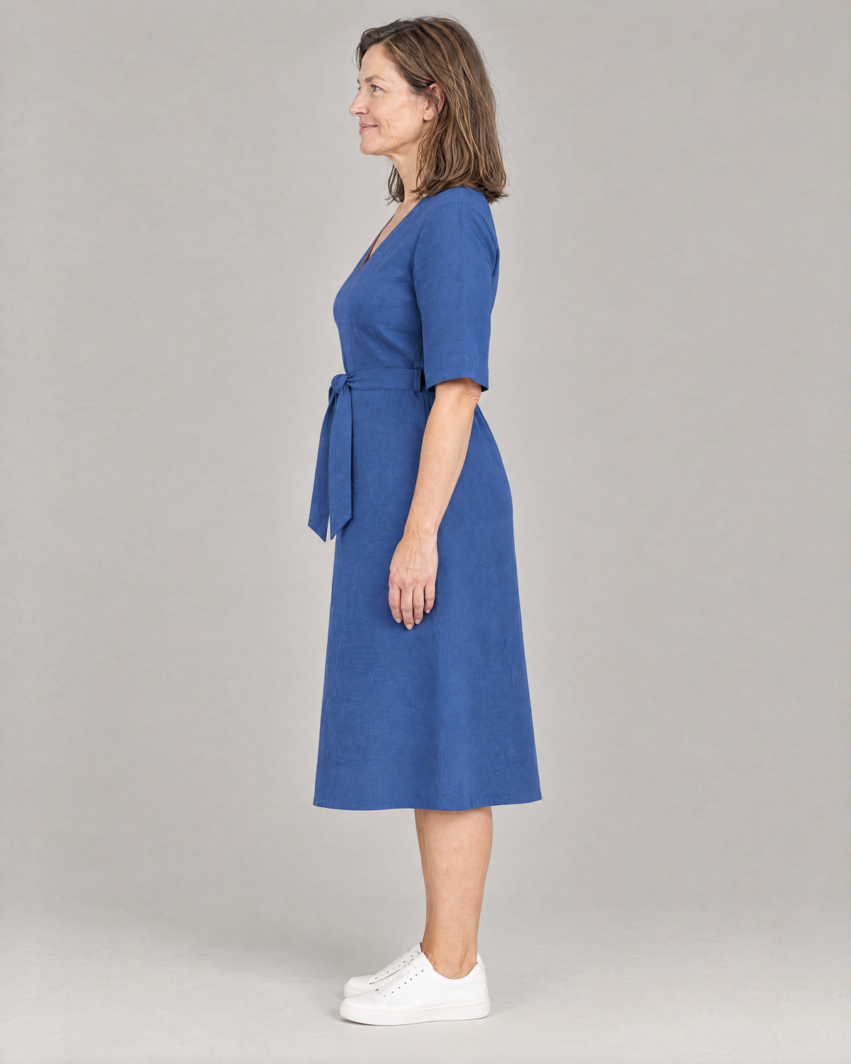 PASSPORT blue linen midi dress, side view showing the gentle A-line skirt and below-the-knee length